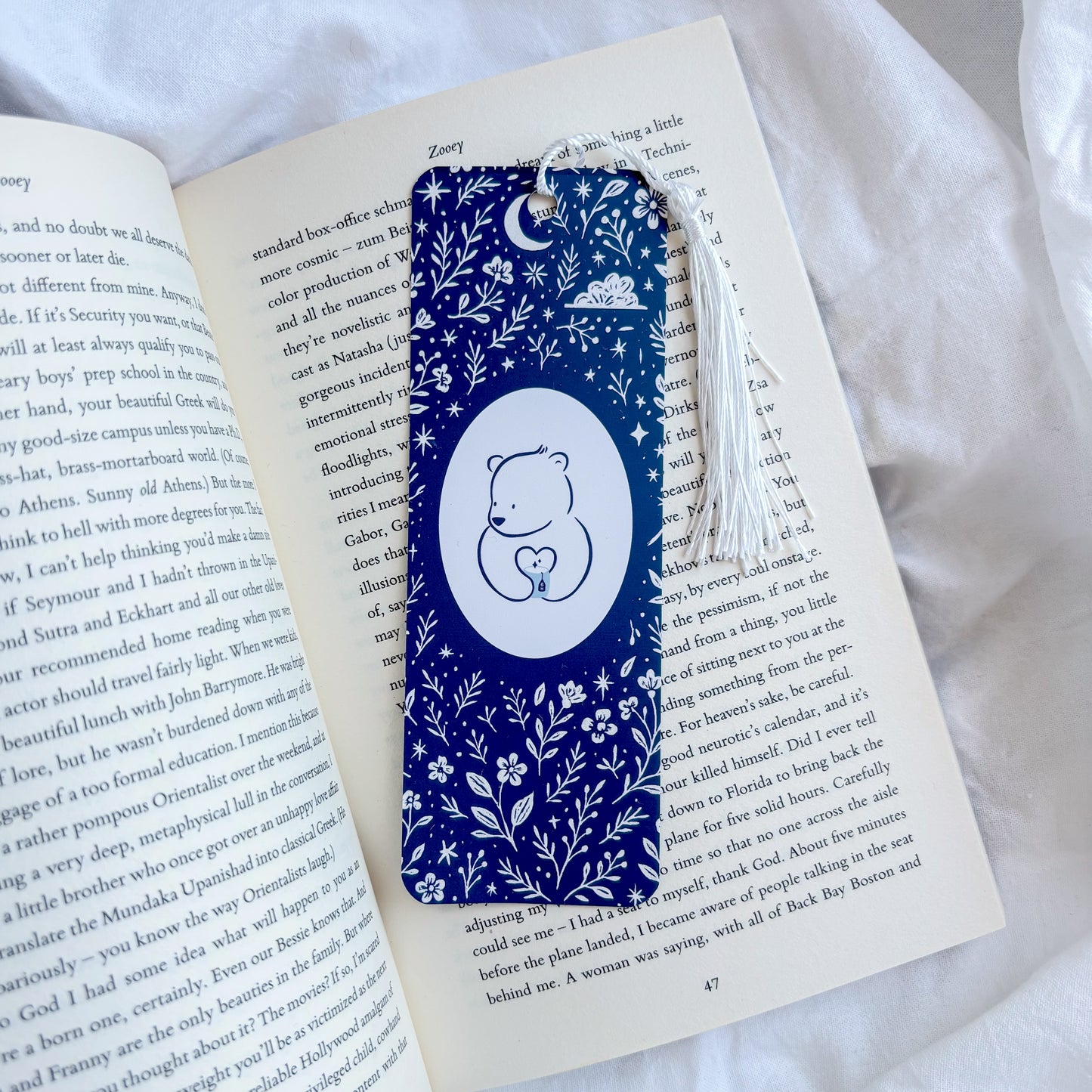 Blue floral bookmark with a white bear design on an open book