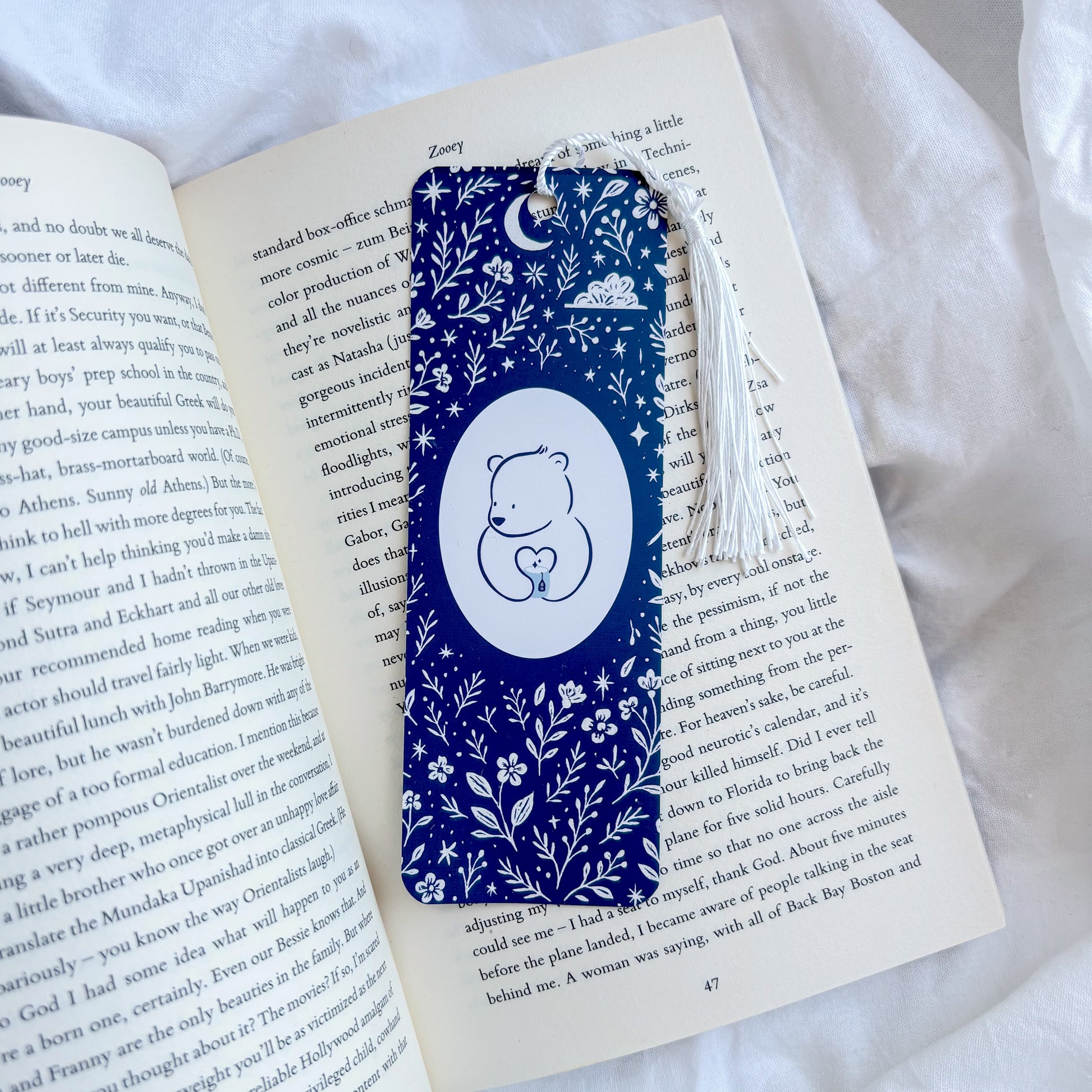 Blue floral bookmark with a white bear design on an open book