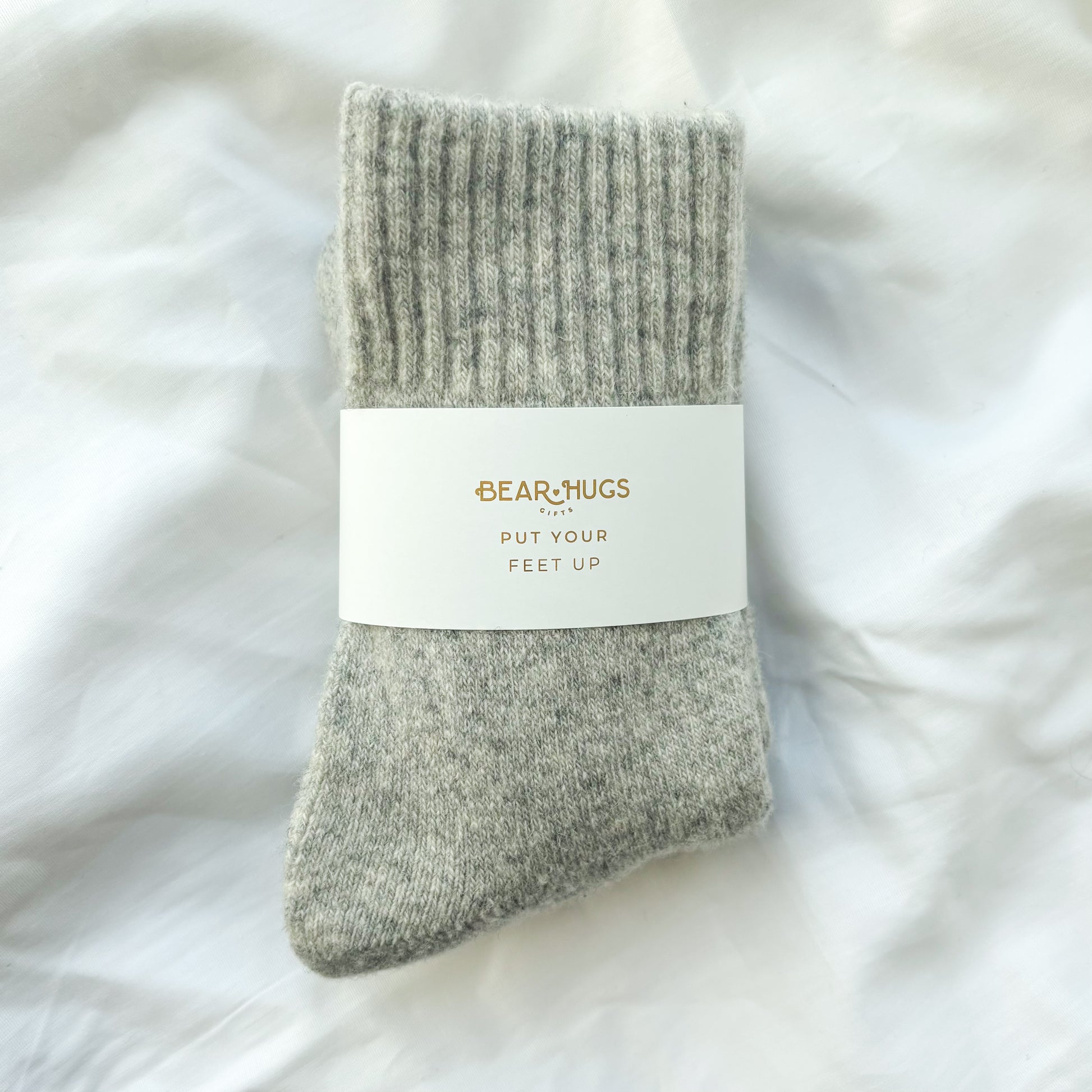 Gray sock with a label on a white fluffy background